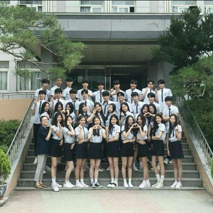 a group of students posing for a photo in front of a building