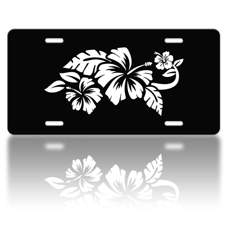 a black license plate with white flowers and leaves on the front, reflecting in water