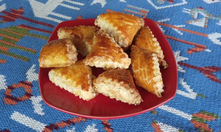 a red plate topped with pastries on top of a blue rug