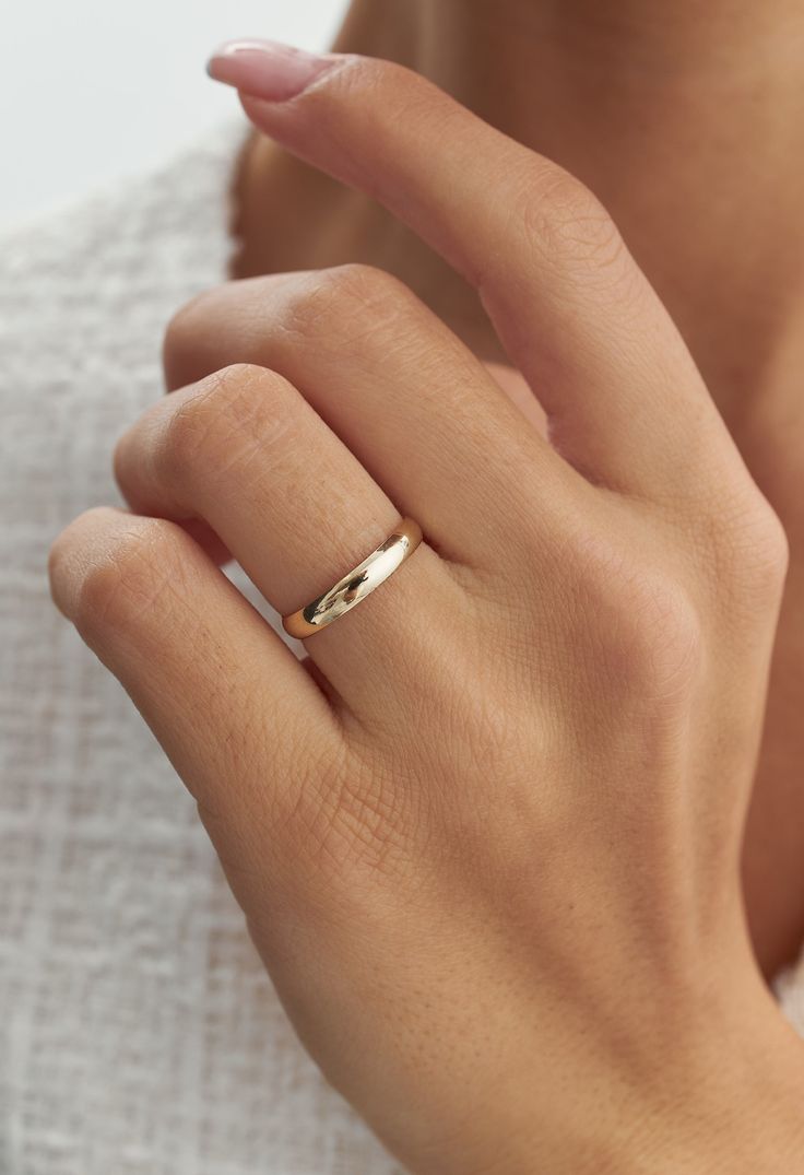 a woman's hand with a gold ring on her finger