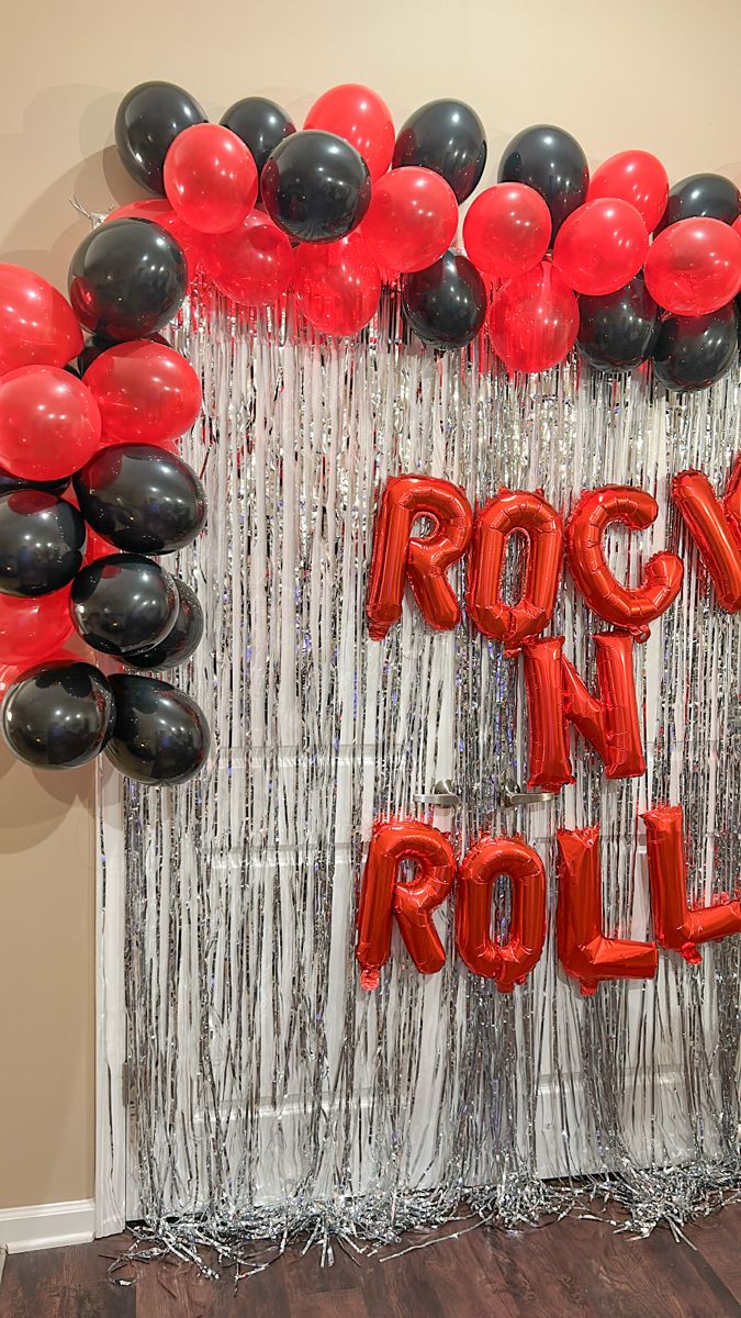 balloons and streamers decorate the backdrop for a rockin'n roll party