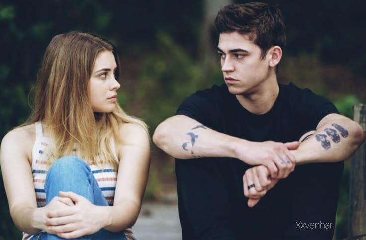 a young man and woman sitting next to each other