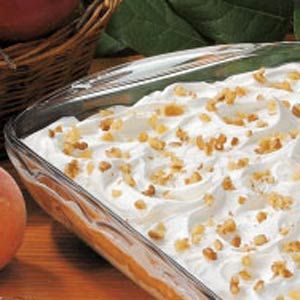 a dessert dish with whipped cream and peaches on the side, next to a basket of apples