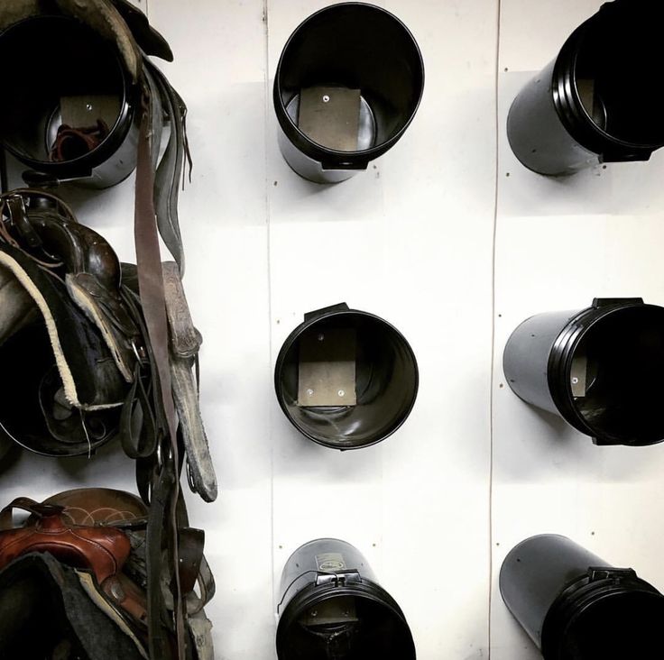 several helmets are hanging on the wall with other items in front of them and one has a camera attached to it