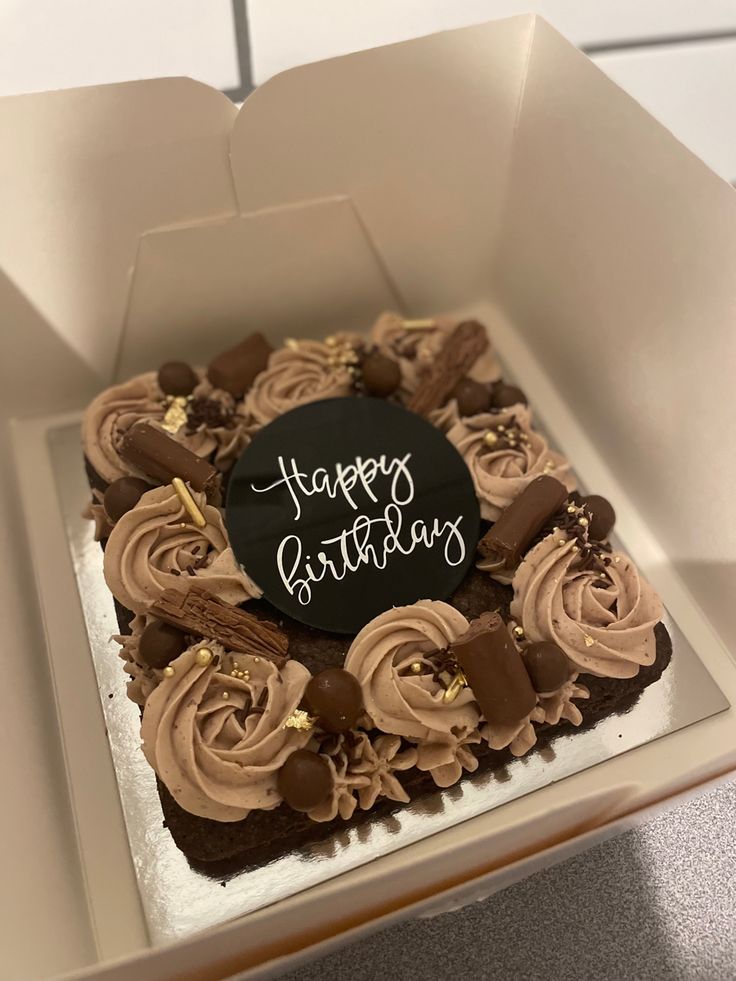 a birthday cake with chocolate frosting in a box