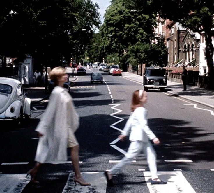 two women crossing the street in front of cars