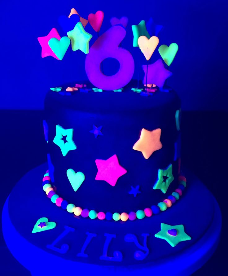 a birthday cake with stars and hearts on it in the dark blue night time light