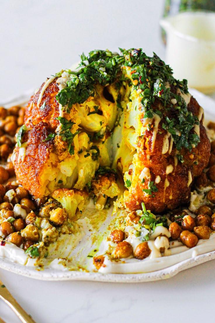 a white plate topped with cauliflower and chickpeas