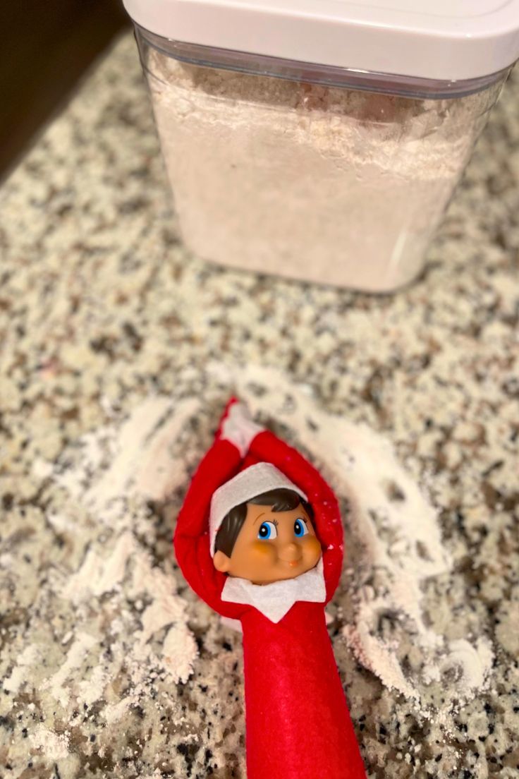 an elf is standing in front of a plastic container