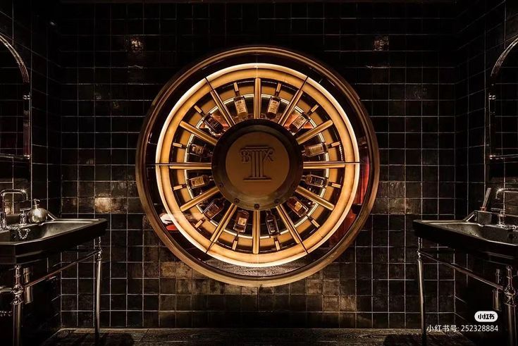 a bathroom with black tile and gold accents