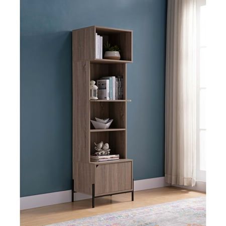 a tall bookcase with three shelves in front of a blue wall