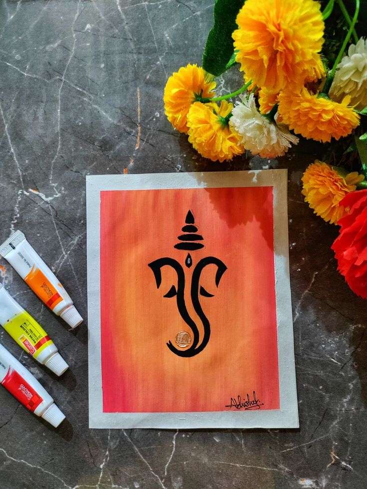 an image of the hindu god ganeshi on a piece of paper next to some flowers