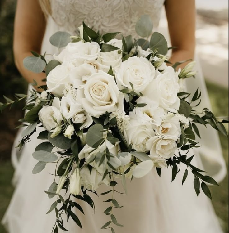 a bridal holding a bouquet of white flowers