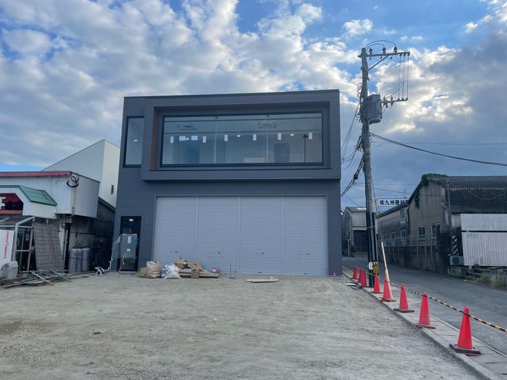 an empty lot with some construction cones around it and a building on the other side