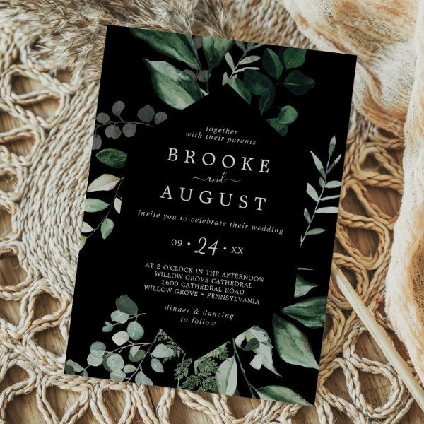 a black and white wedding card with greenery on it, next to a lace doily