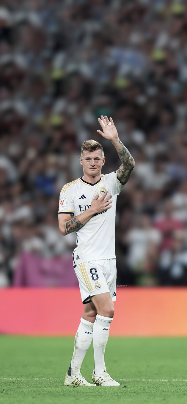 a male soccer player is holding his hand up in the air while standing on a field