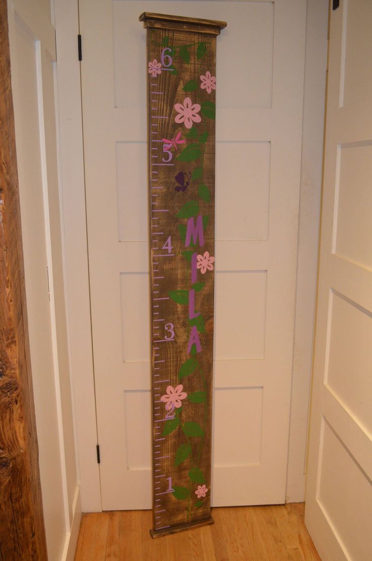 a wooden ruler with flowers on it in front of a door that says, mama