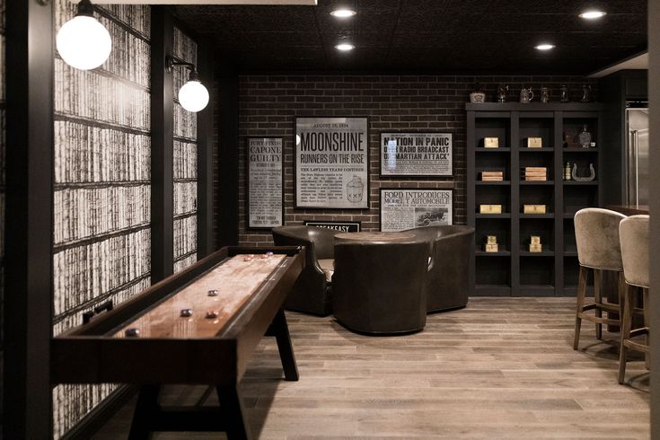 a game room with a pool table and several stools in front of the bar