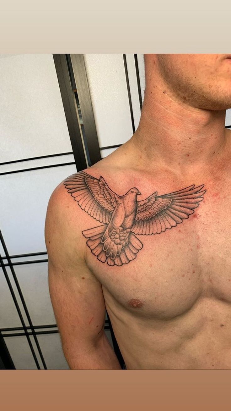 a man's chest with a bird tattoo on his left arm and chest is shown