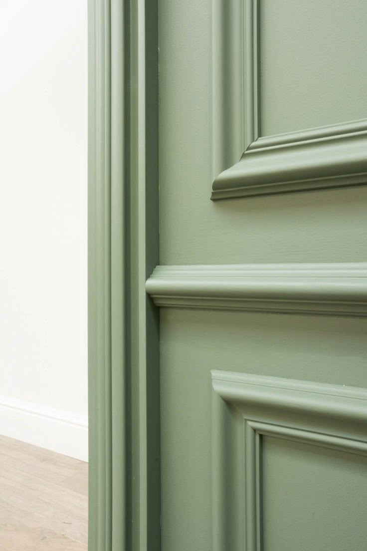 an open door with green paint and wood flooring