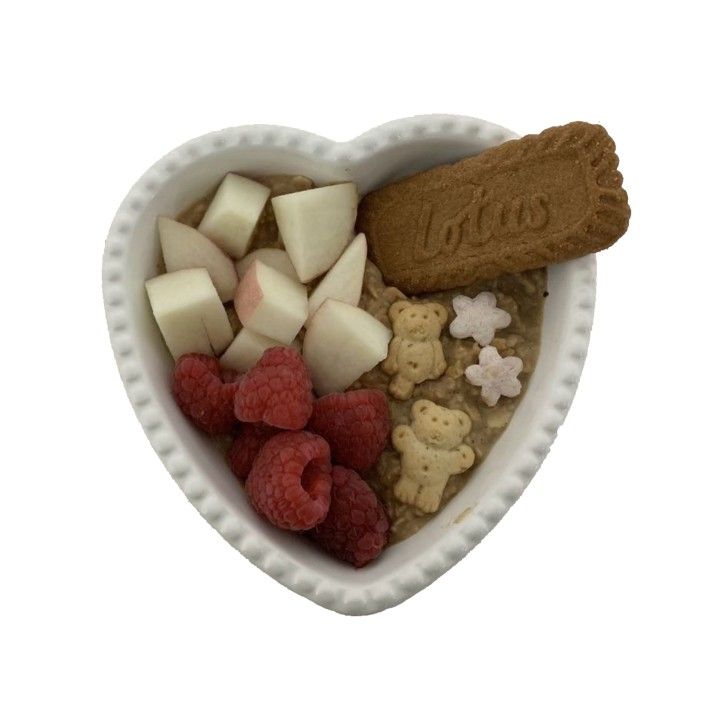 a heart shaped bowl filled with fruit and cookies