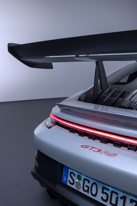 the back end of a silver sports car with its trunk open and it's lights on