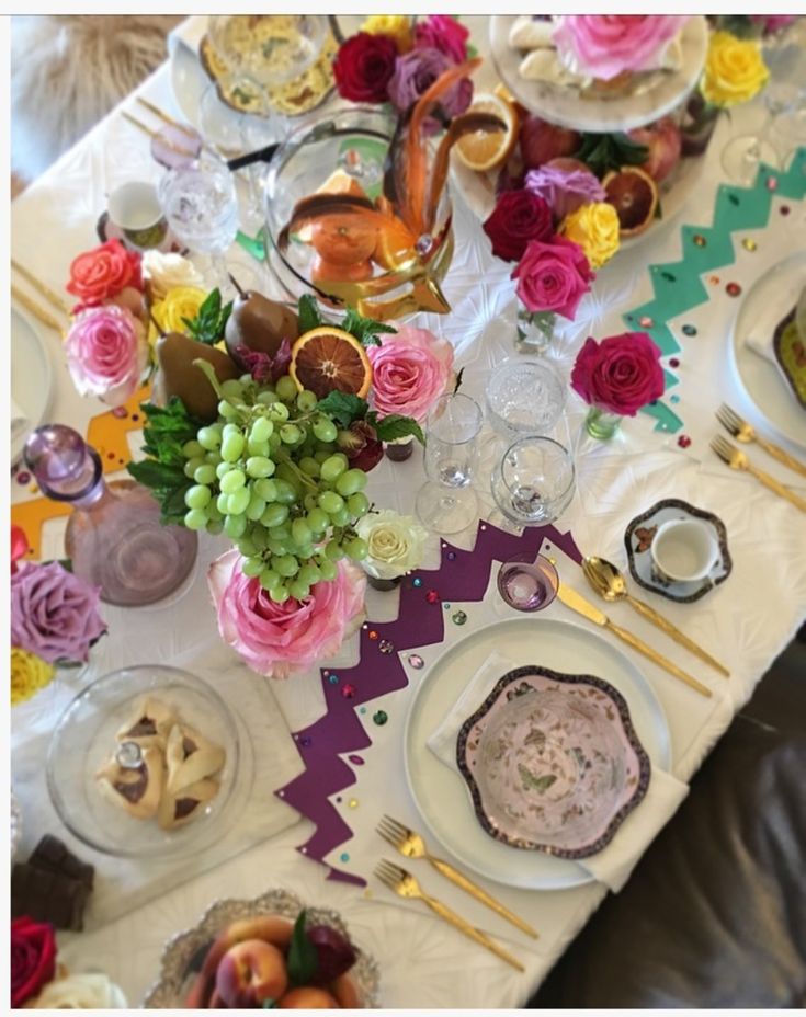 the table is set with flowers and plates