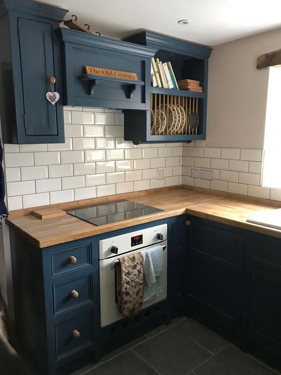 a kitchen with blue cabinets and wooden counter tops