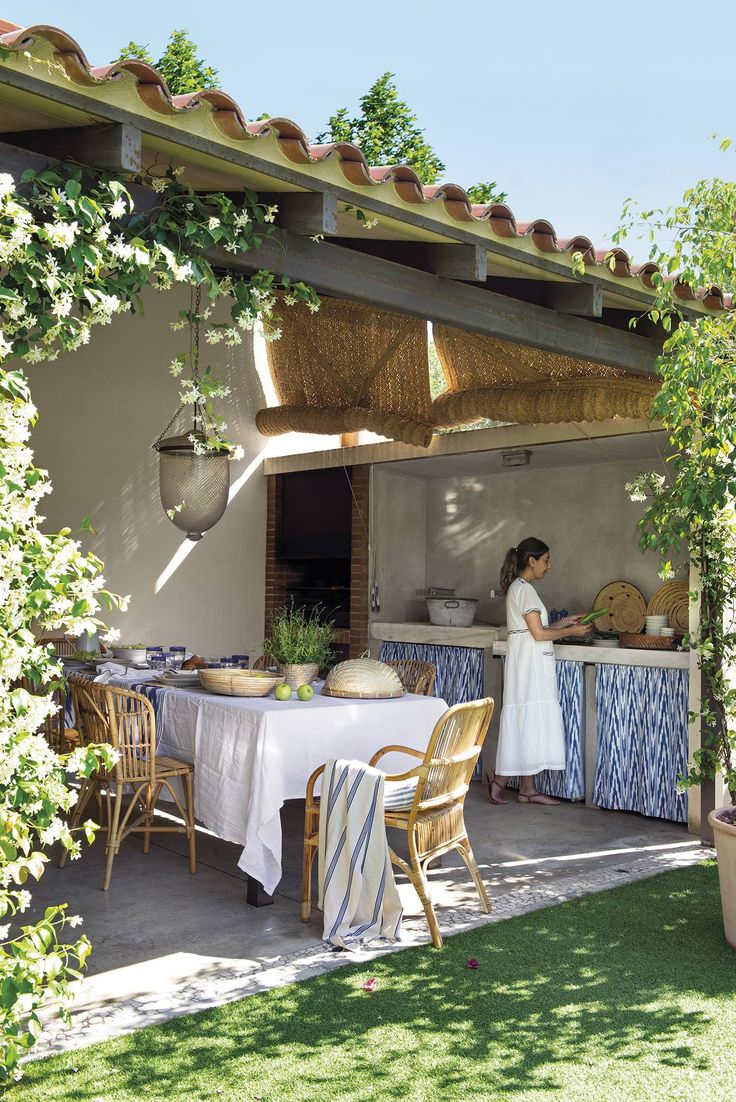 a woman standing in front of a table with food on it under an awning