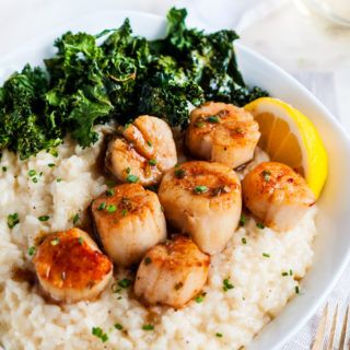 a white plate topped with rice and scallops