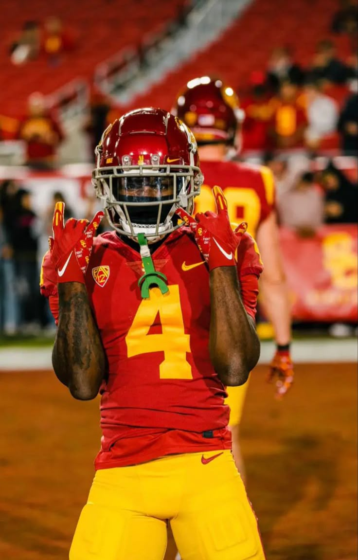 a football player holding his hands up in the air