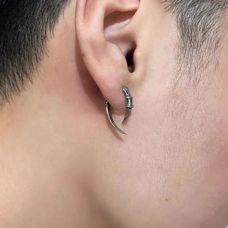 a man wearing a pair of silver ear piercings