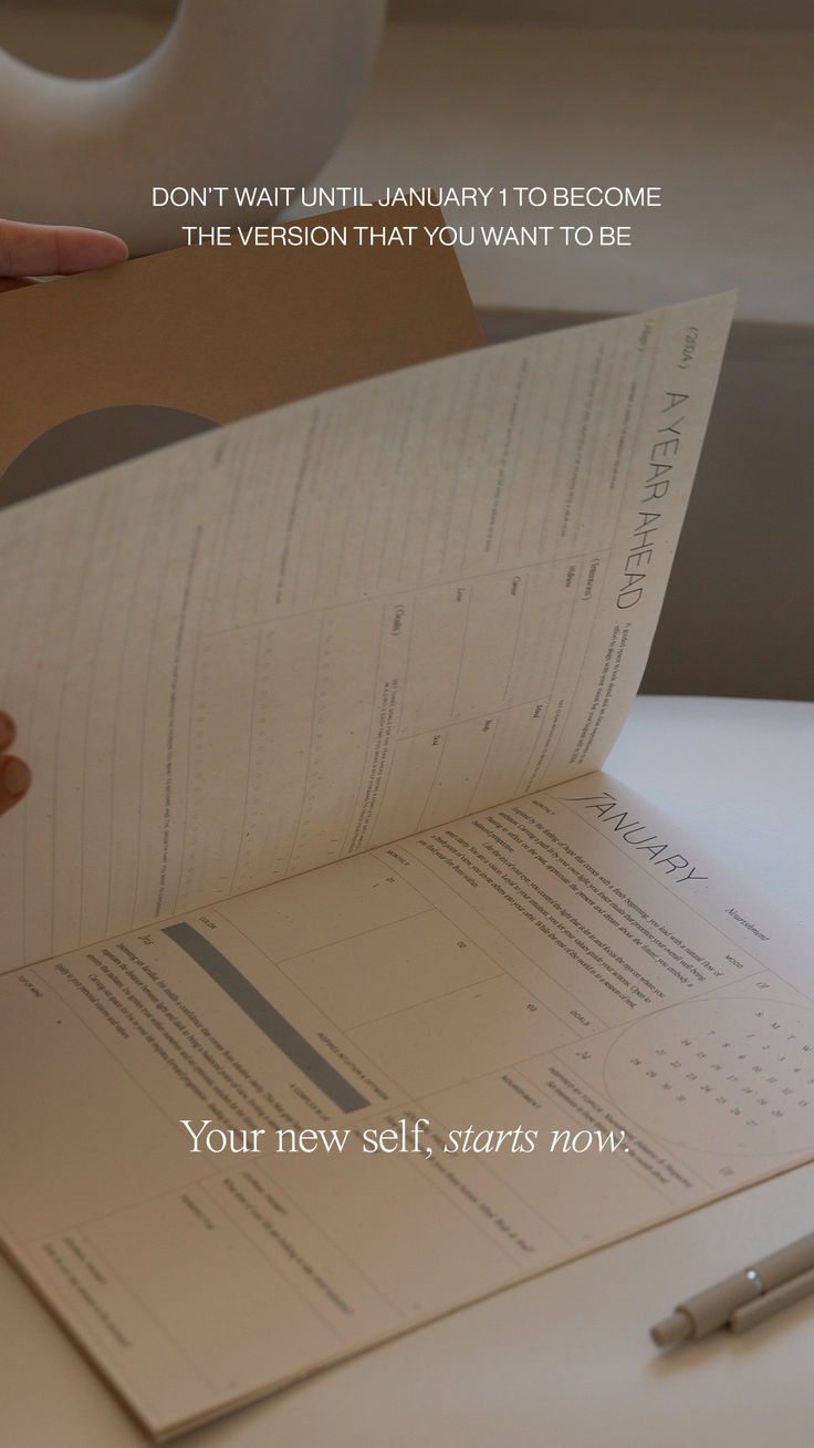 someone is holding an apple book open on a table with a pen next to it