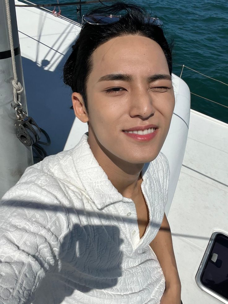 a man sitting on top of a boat next to the ocean