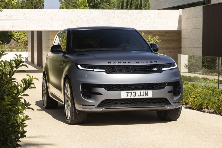 a grey range rover parked in front of a house