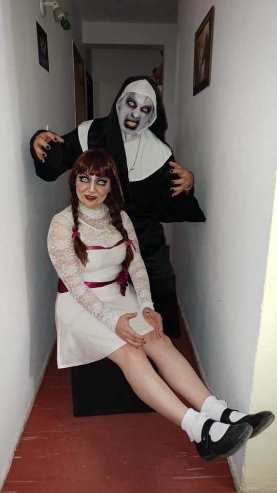 two people dressed up as the bride and groom sitting on a bench in a hallway