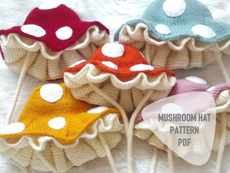 four knitted mushroom hats with white polka dots on them, all in different colors