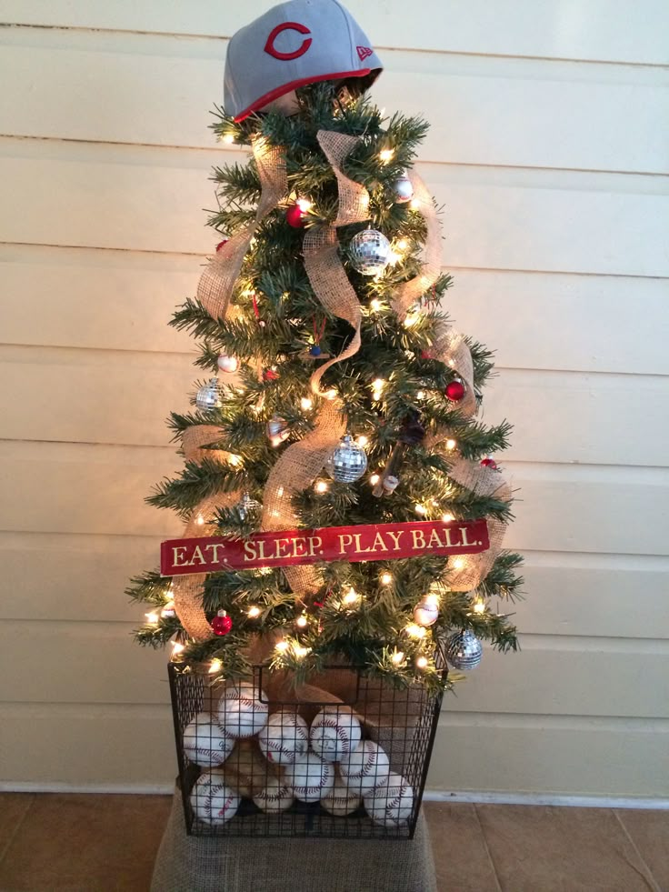 a christmas tree with lights and baseball caps on it, in front of a house