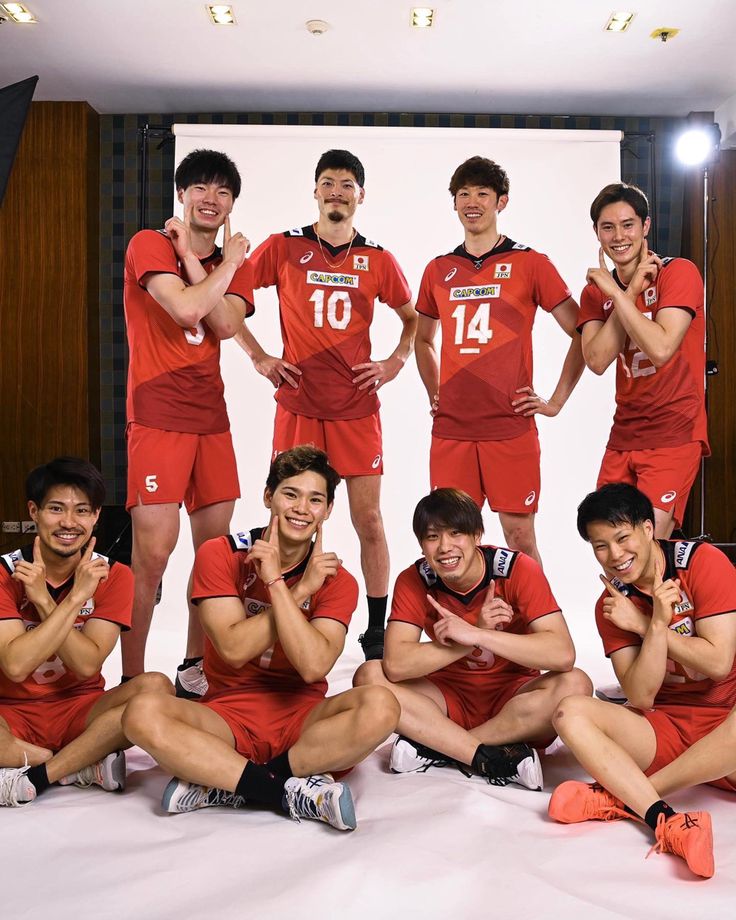 a group of men in red uniforms posing for a photo