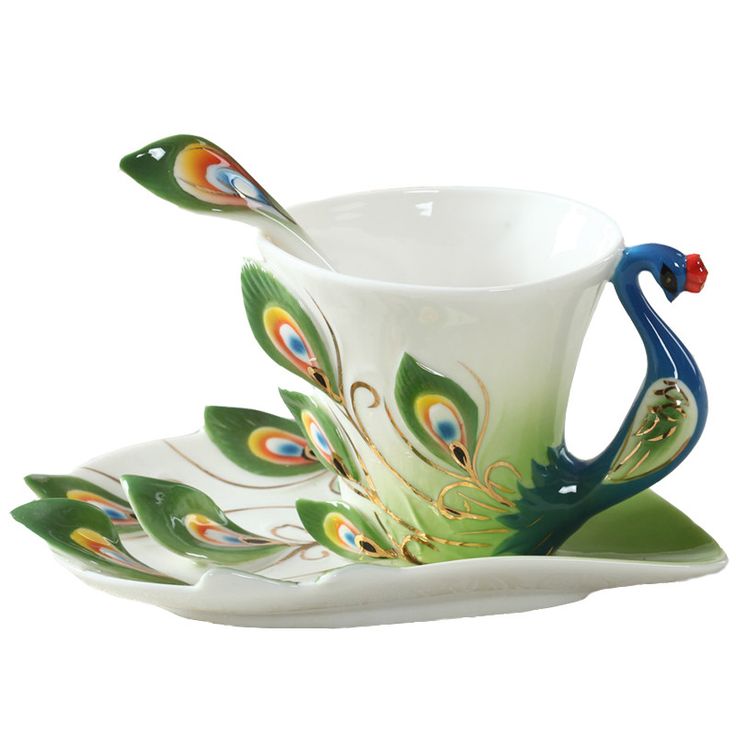 a tea cup and saucer decorated with peacock feathers