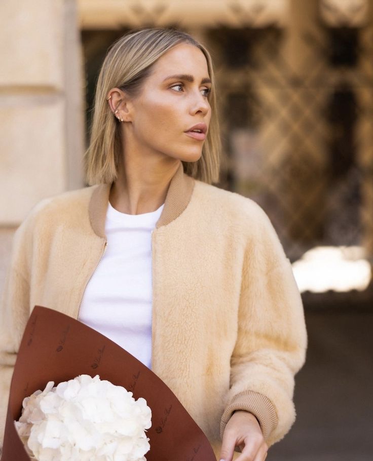 a woman holding a bouquet of white flowers