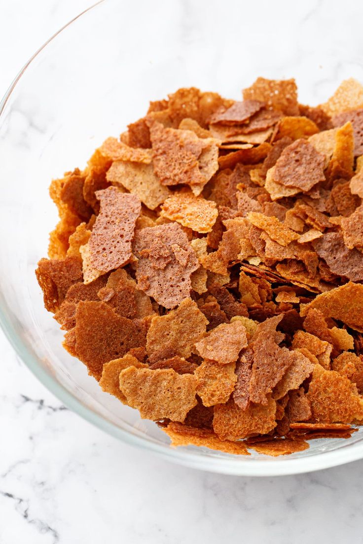 a glass bowl filled with chips on top of a marble counter