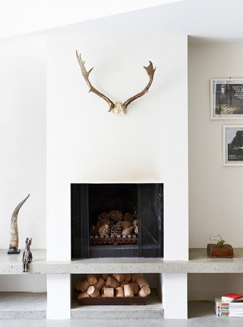 a living room filled with furniture and a fire place next to a wall mounted deer head