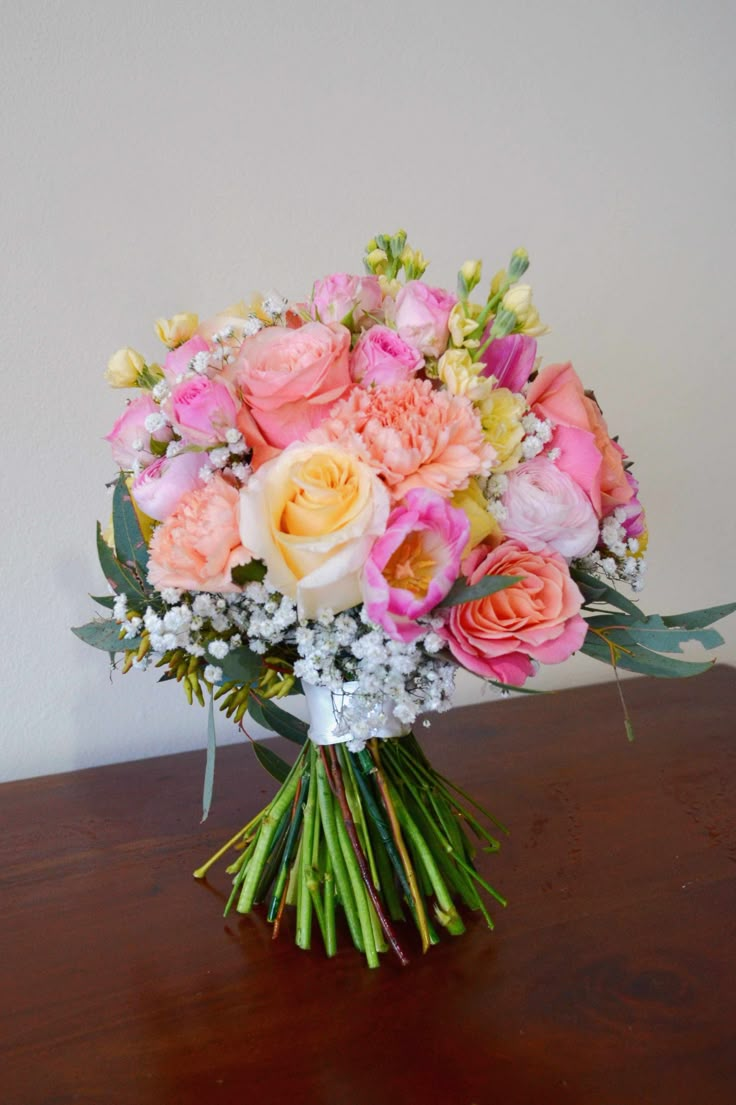 a bouquet of flowers sitting on top of a wooden table