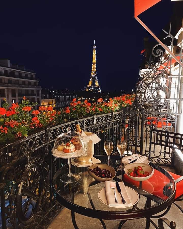 a table with food and drinks on it in front of the eiffel tower