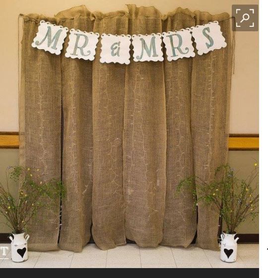 a couple of vases with plants in front of a burlocked curtain