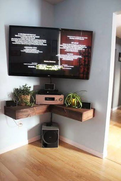 a flat screen tv sitting on top of a wooden shelf next to a wall mounted television