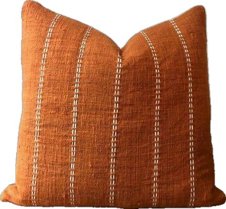 an orange pillow with white stitches on it