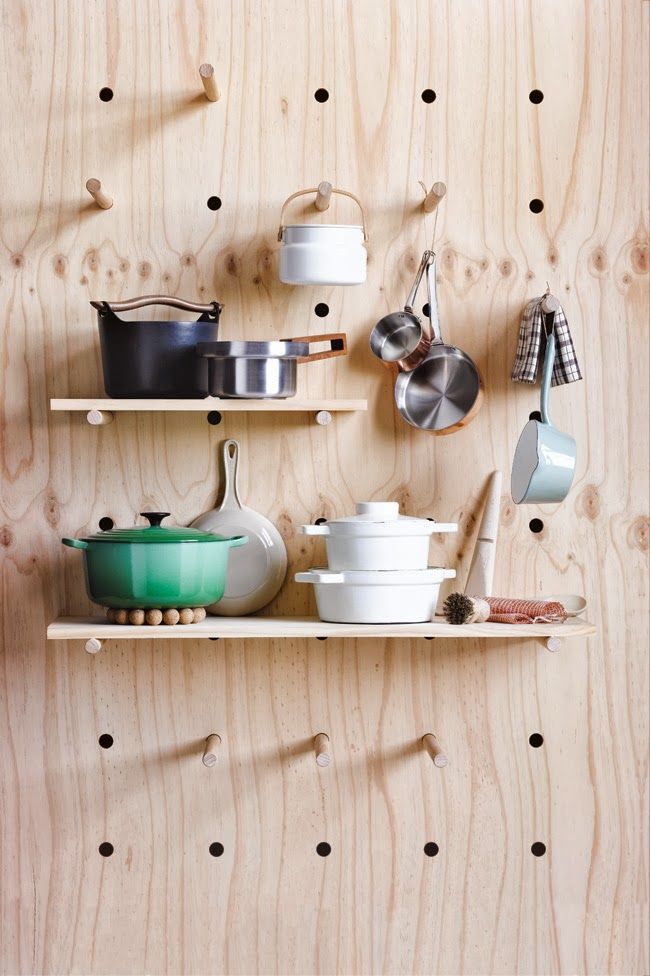 shelves with pots and pans on them against a wooden wall covered in polka dots