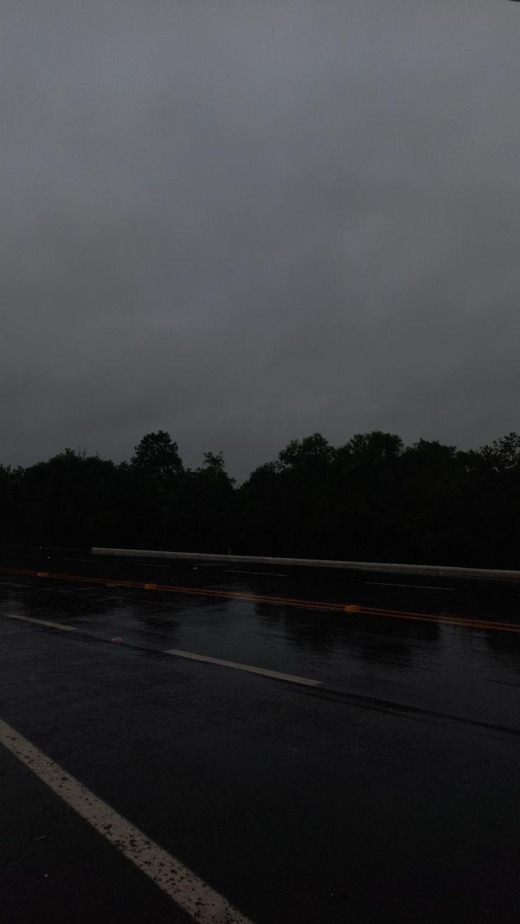 an empty parking lot at night with no one on the road or in the rain